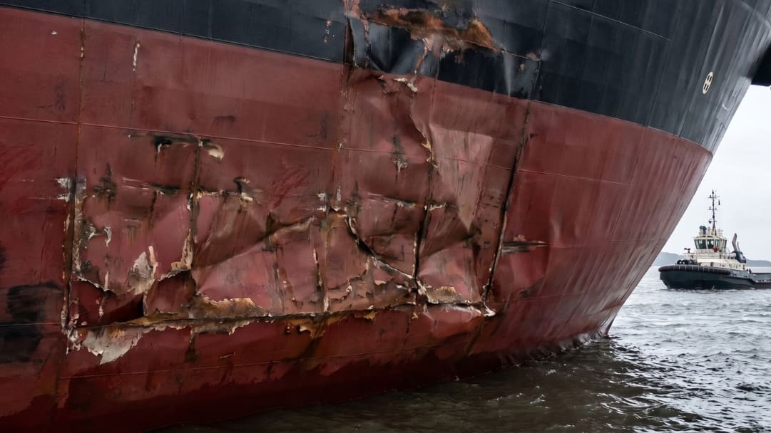 Damaged shell plating under repair alongside beneath work lights