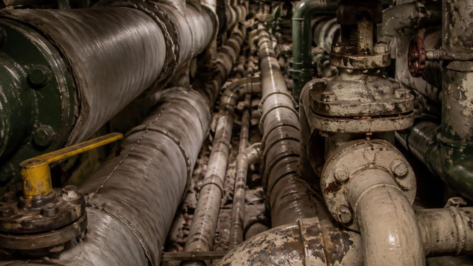 Technician working on marine piping in a confined machinery space